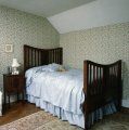 dormitor cu mobilier lemn si tapet floral
