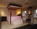 dormitor pat inalt roz cu baldachin
