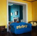 living cu sofa albastra si pereti galbeni